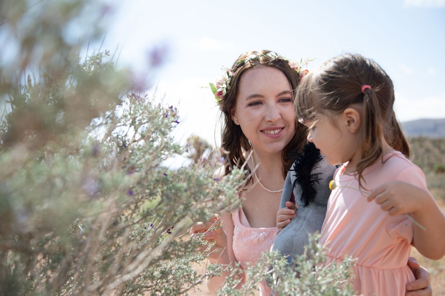 Intimate moment captured among purple desert wildflowers with mountains in background.