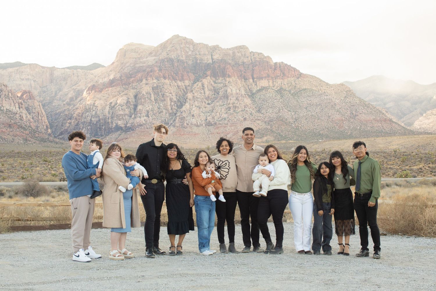 A group poses together for a photo with red rock mountains visible in the background.