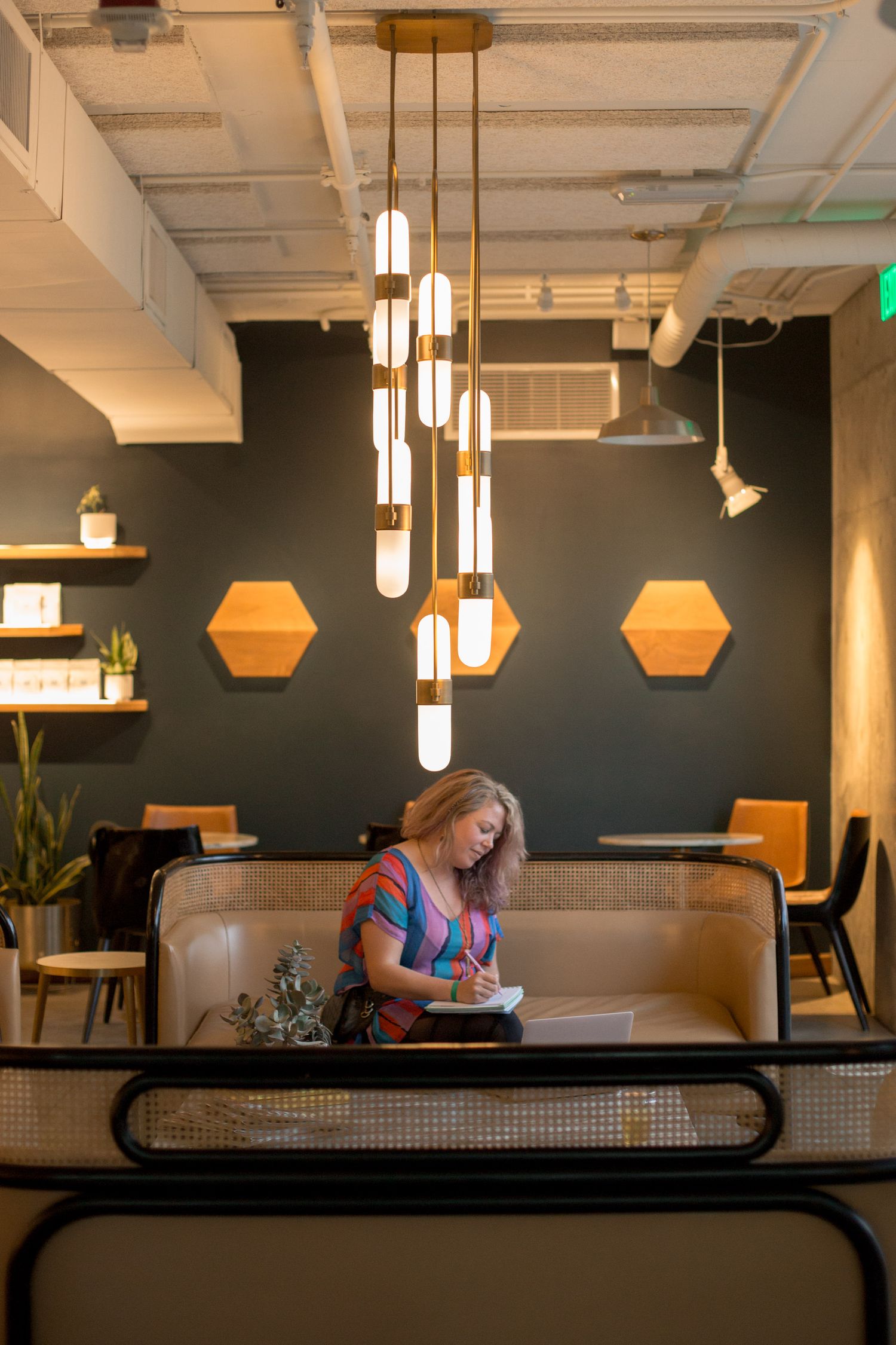 Modern cafe interior with pendant lights and booth seating against dark walls.