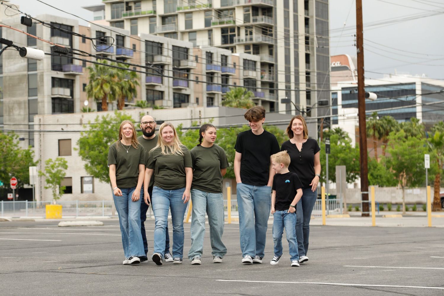 Group walking together down a city street wearing coordinated casual outfits.