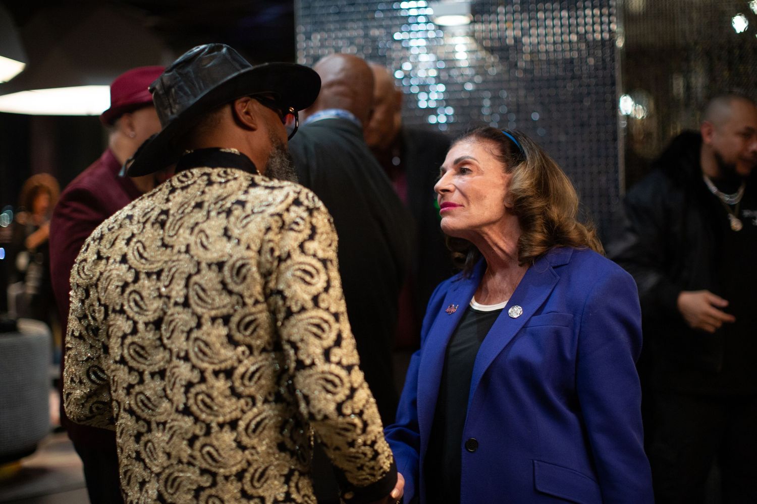 Two attendees having an animated conversation at an evening social event.