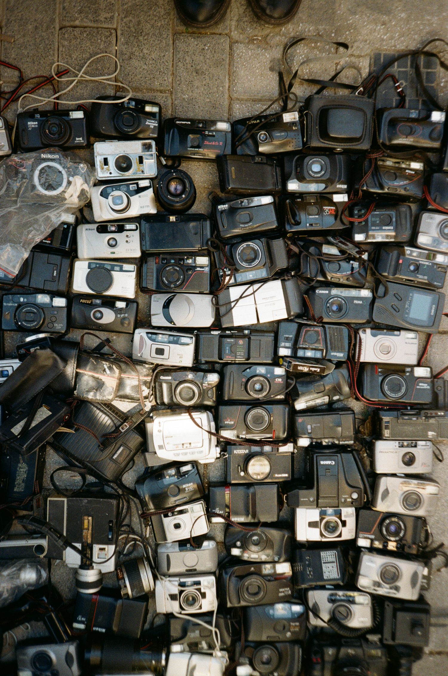 A collection of vintage film cameras stacked together showing various analog photography equipment in black and silver.