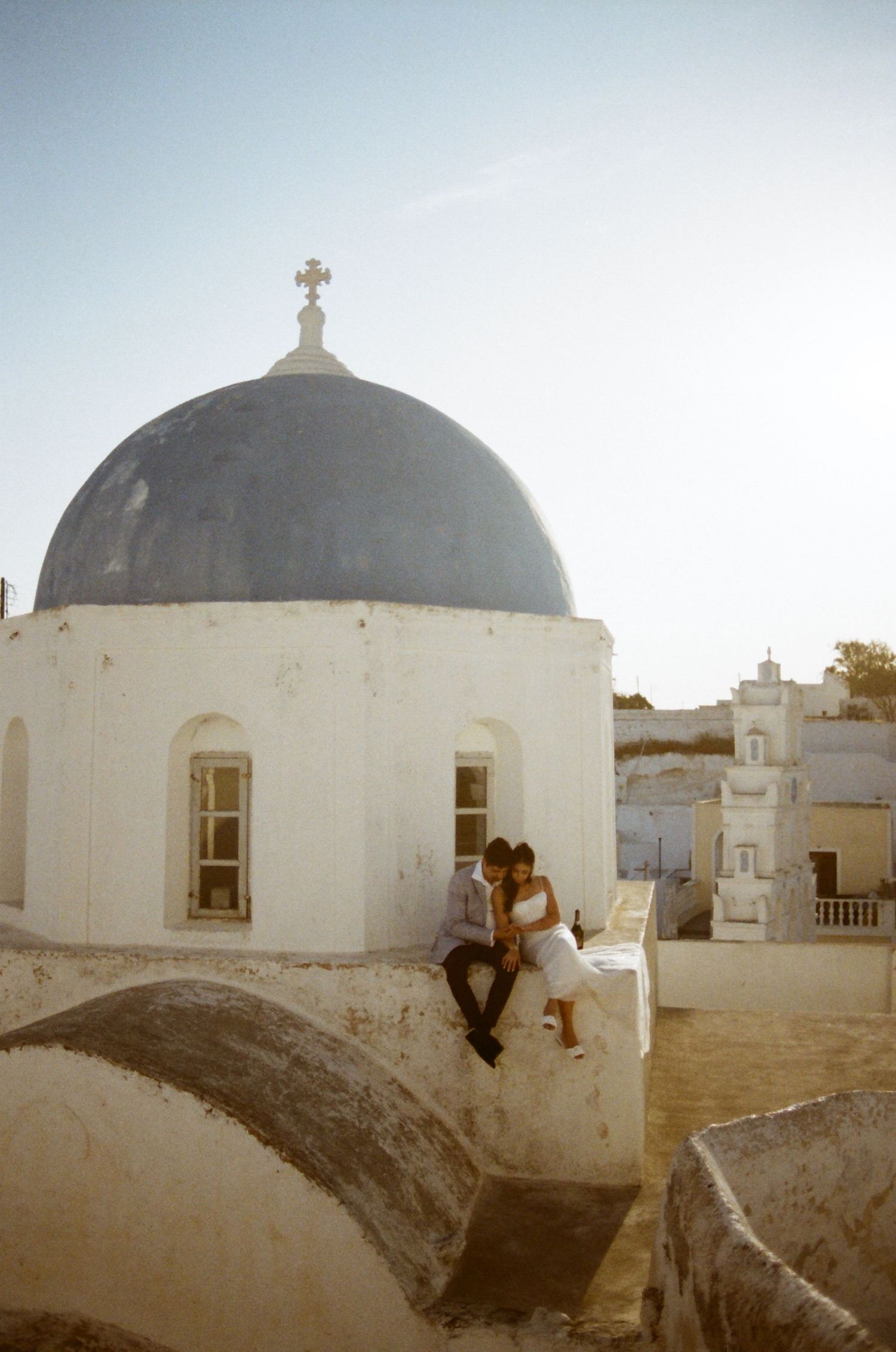 A series of white domed churches with crosses in Patmos, Greece against a light sky background.