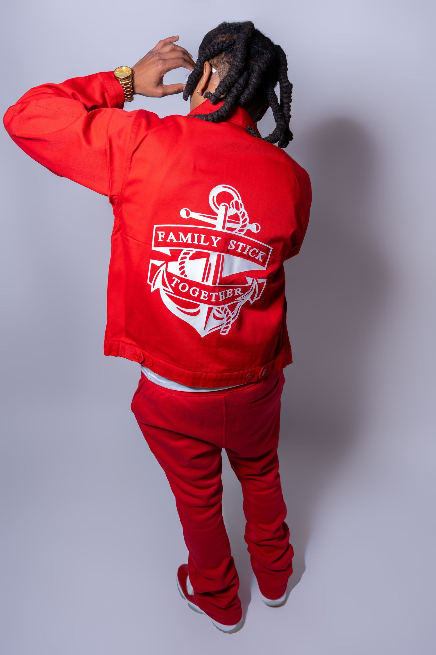 Red jacket with white anchor Family Stick Together graphic on back, worn with matching red outfit.