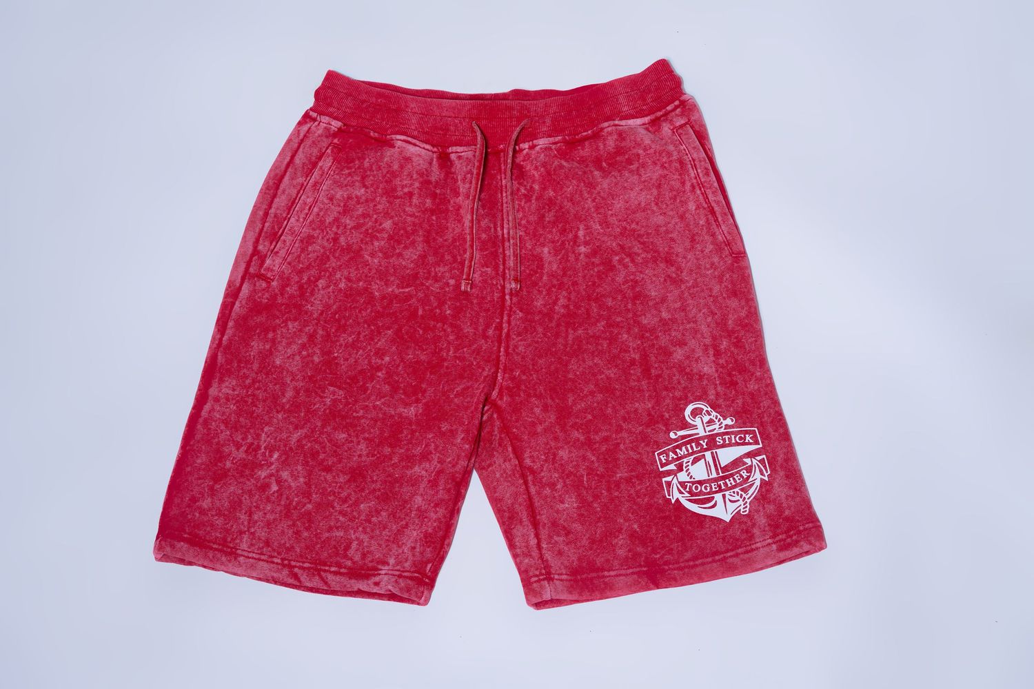 Red acid wash drawstring shorts with white Family Stick Together anchor graphic print.