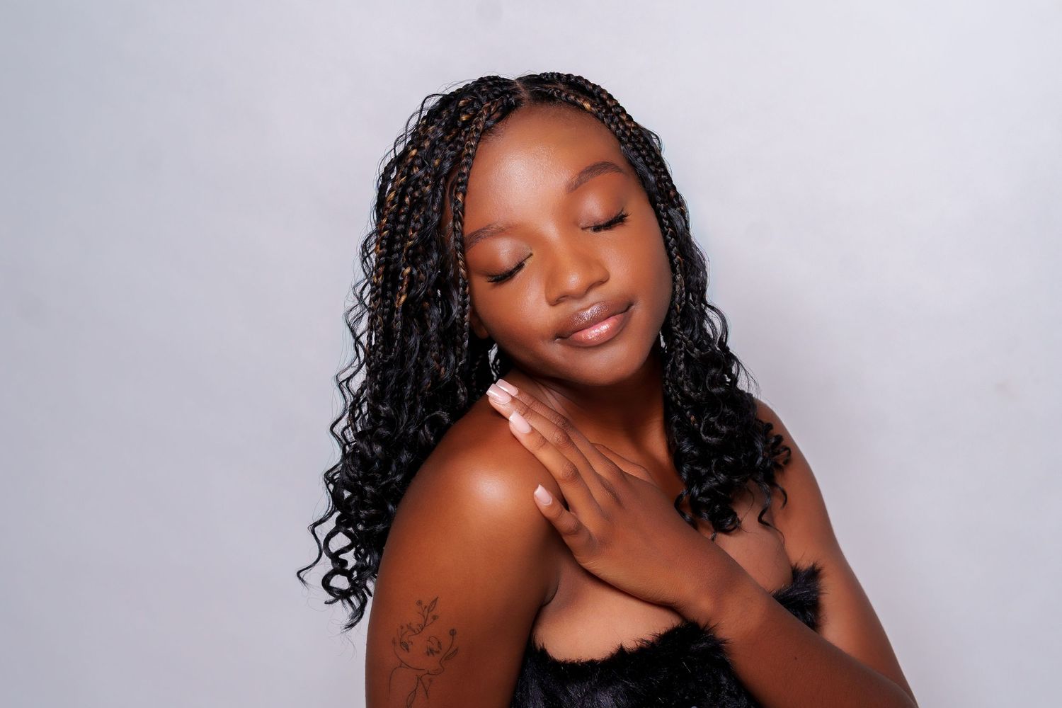 Young woman with braided hair posing gracefully in studio portrait.