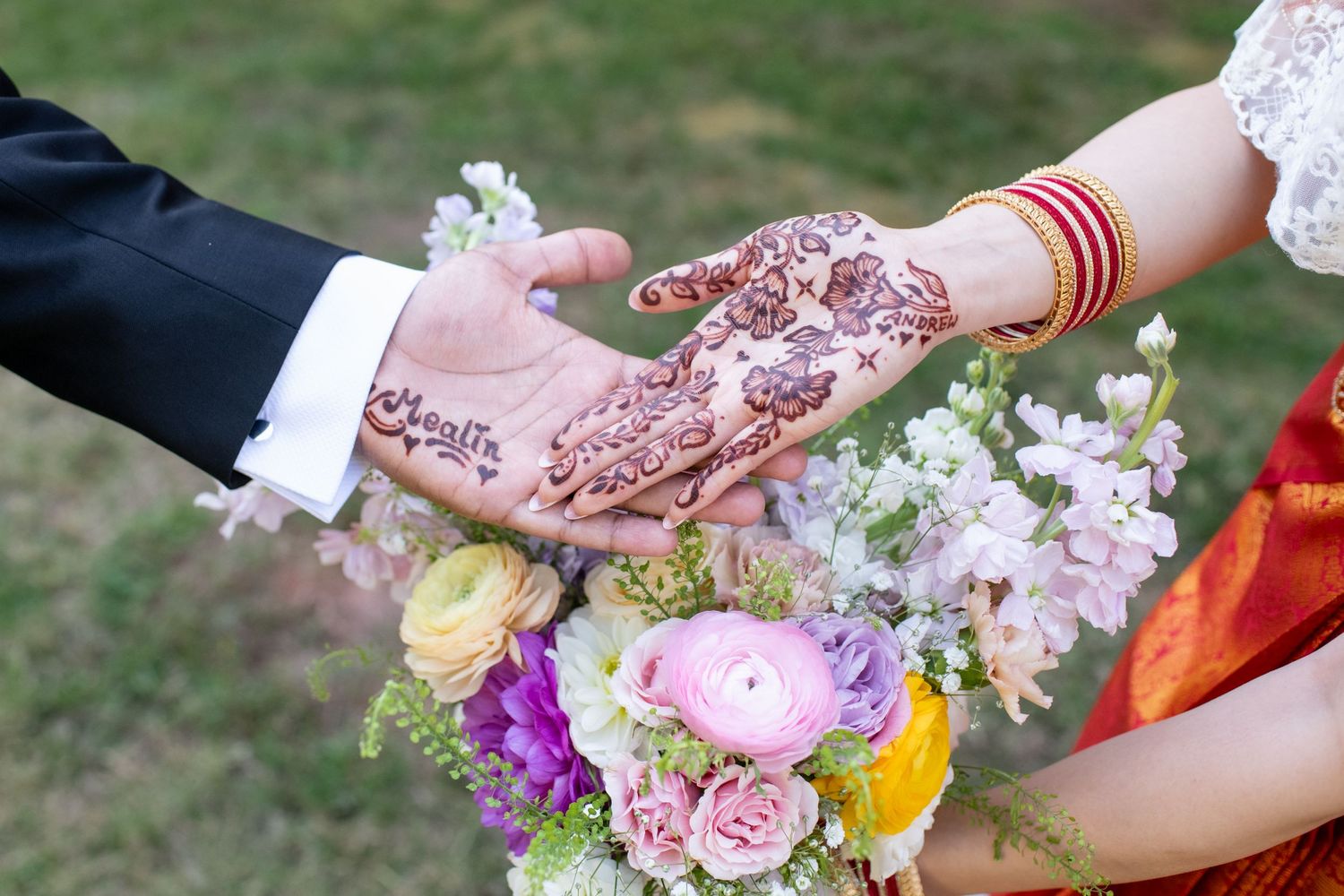 Hands arranging delicate flowers and petals for a floral design workshop in an outdoor garden setting.