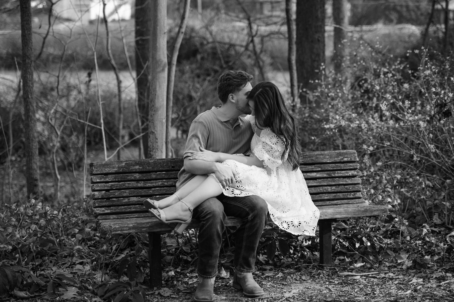 Black and white photo series of a couple's romantic moments on a park bench.