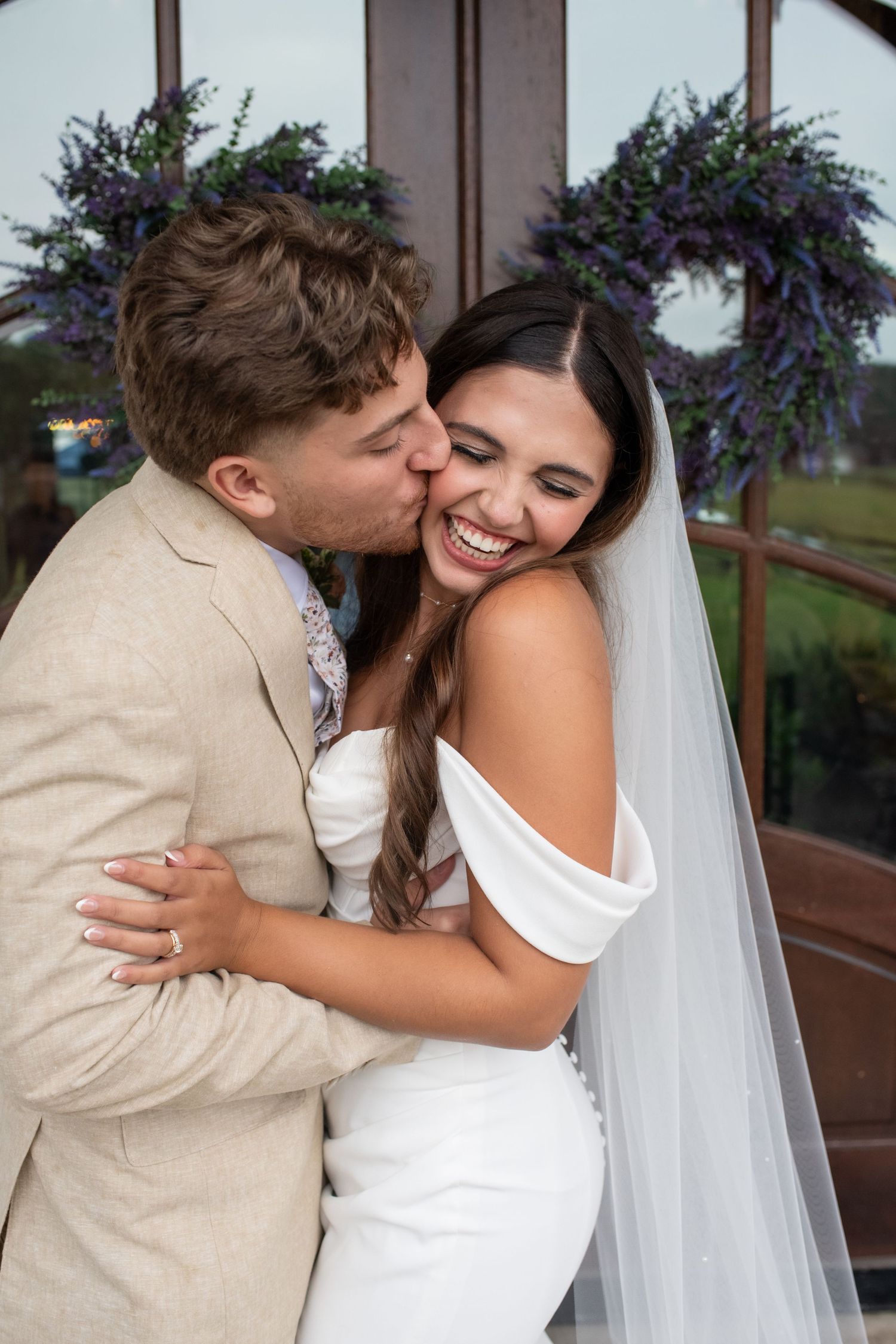 A joyful moment captured against a backdrop of purple floral wreaths.