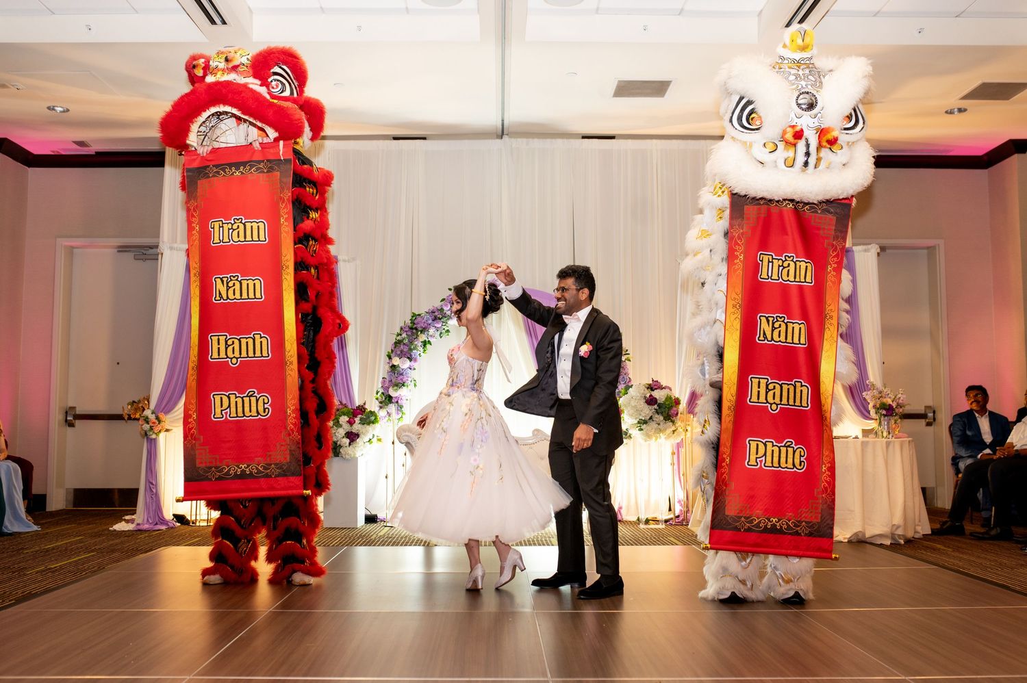 Wedding reception with traditional Chinese lion dance performers in red costumes.