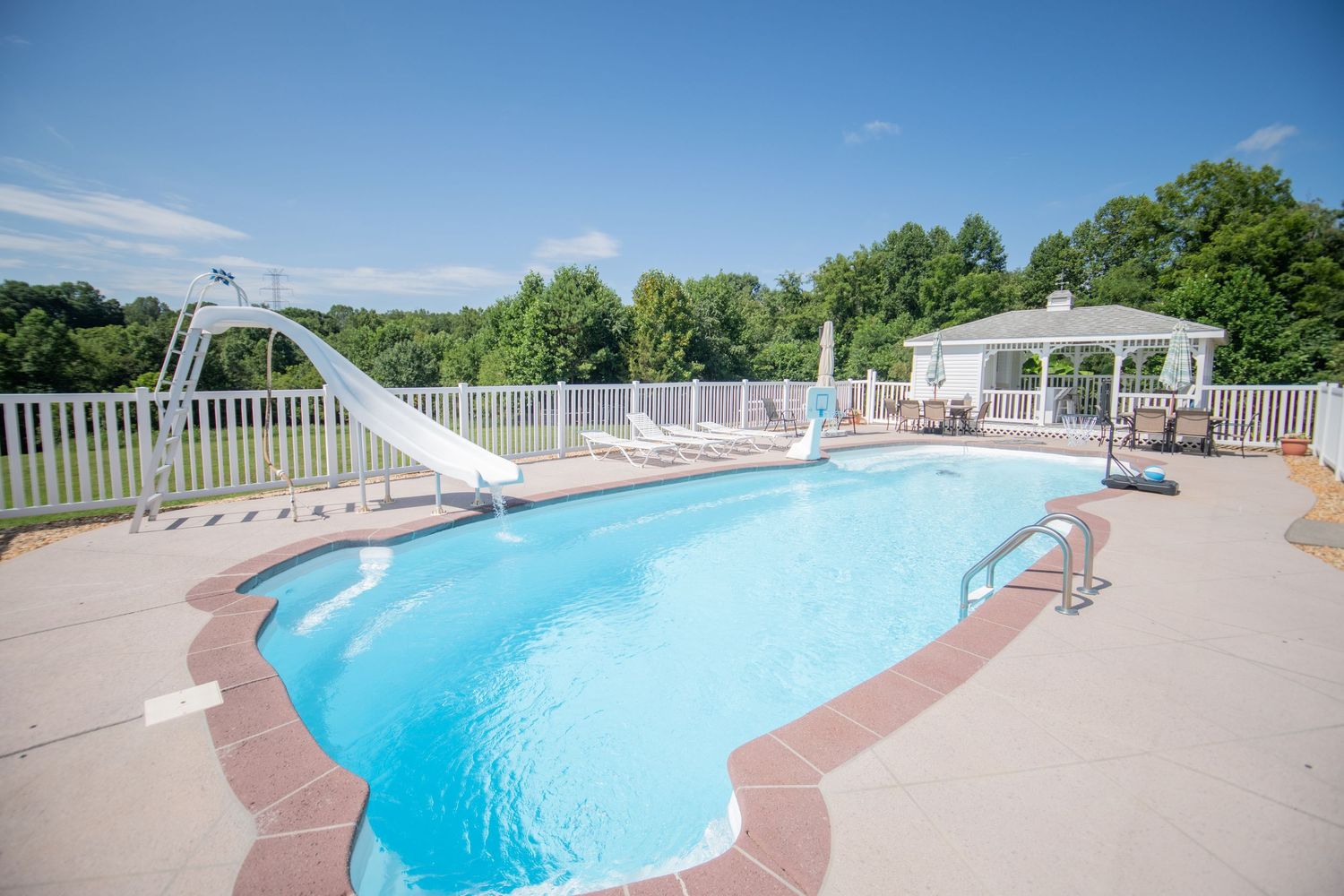 Expansive swimming pool with white safety railings and ample deck space for lounging.