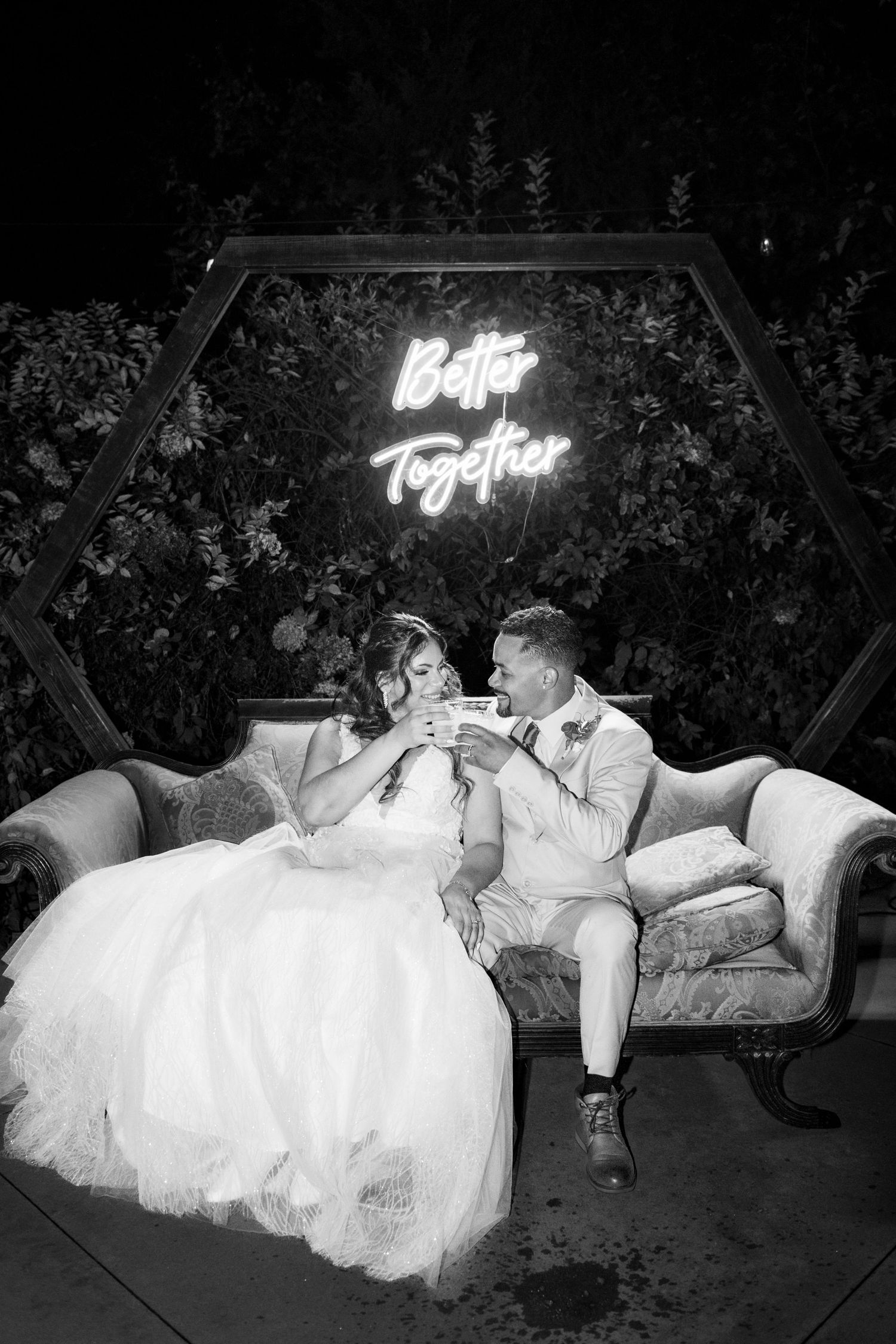 A romantic black and white photo sequence shows a couple in wedding attire relaxing on outdoor furniture at night.