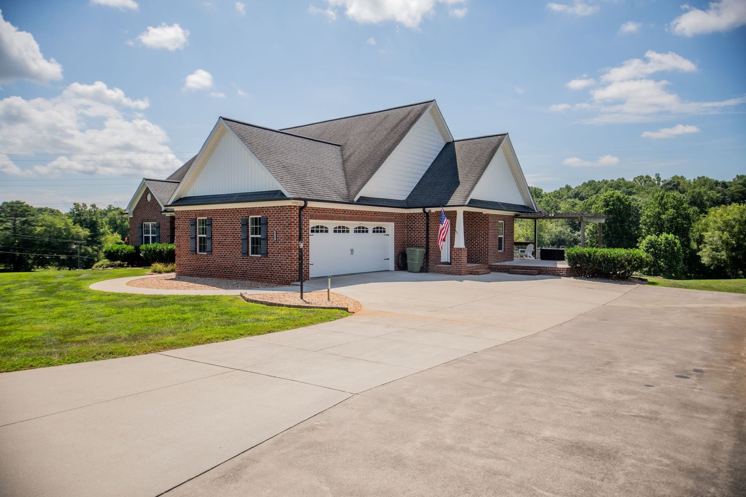 Long concrete driveway leading to multiple brick homes with attached garages.