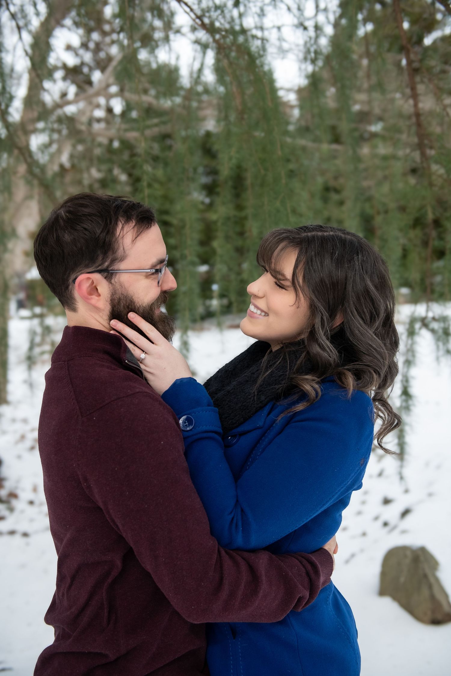 A romantic winter engagement photo session showing playful moments between a couple.