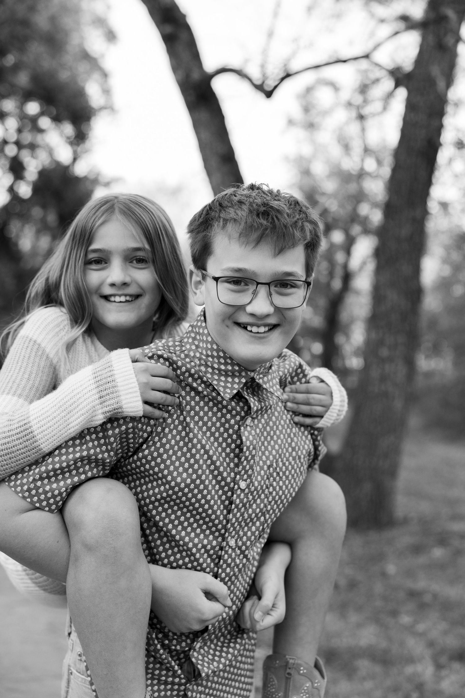Playful black and white portrait of siblings having fun outdoors.