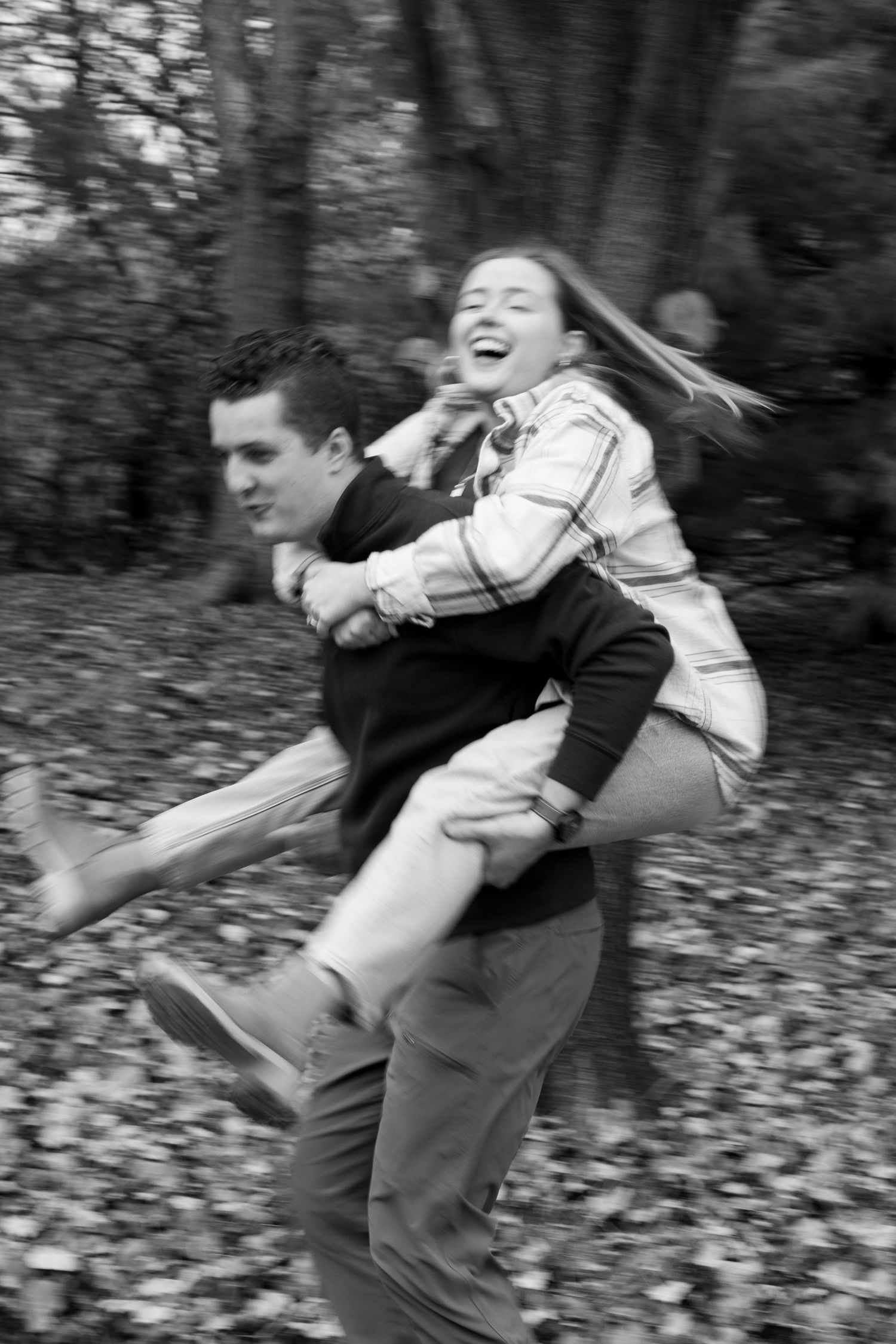 A playful sequence of black and white photos showing two people spinning and laughing together outdoors.
