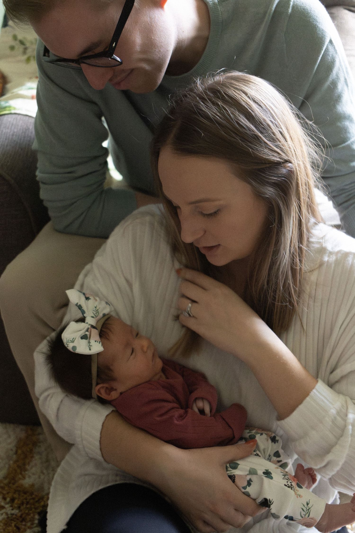 A gentle family moment captured while cradling a sleeping baby in a floral outfit.