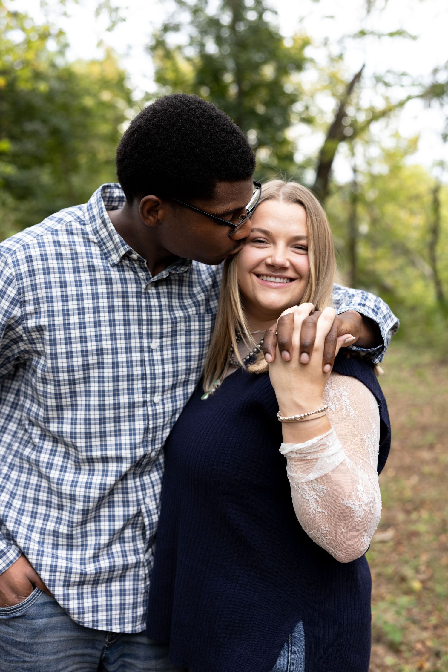 Couple kissing and holding hands during an engagement session