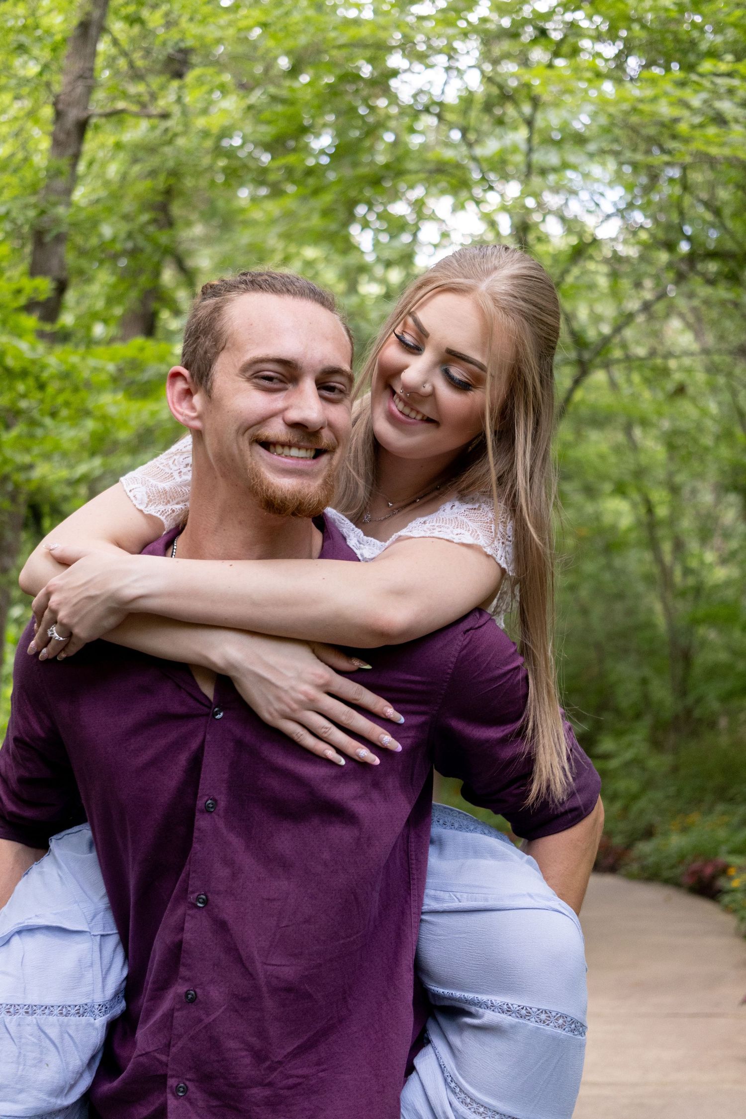 A playful piggyback ride moment captured on a tree-lined path.