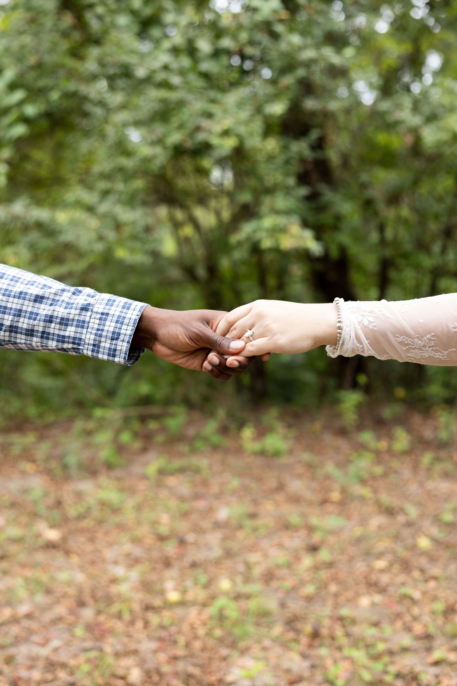 Two hands reach out to each other in a passing gesture against a blurred natural outdoor background.