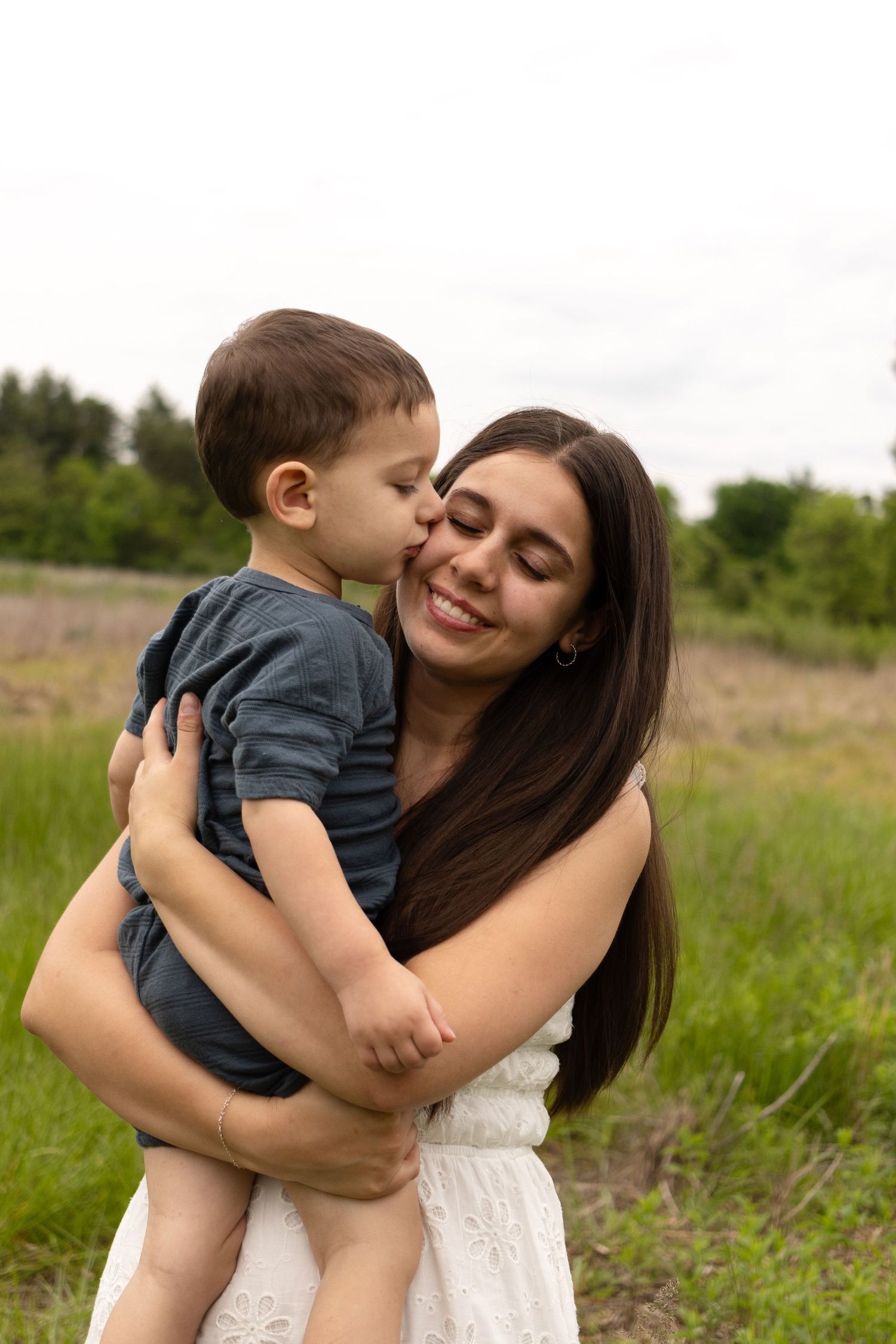 A tender moment between parent and child in a sunny meadow.
