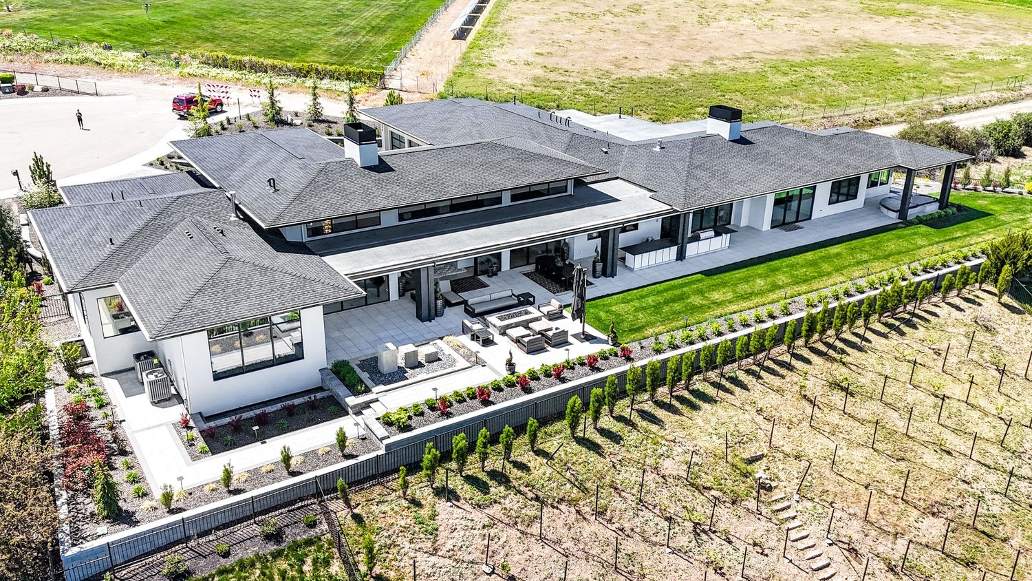 Aerial view of a modern house with a terraced rice paddy field in the backyard creating a unique landscaping pattern.