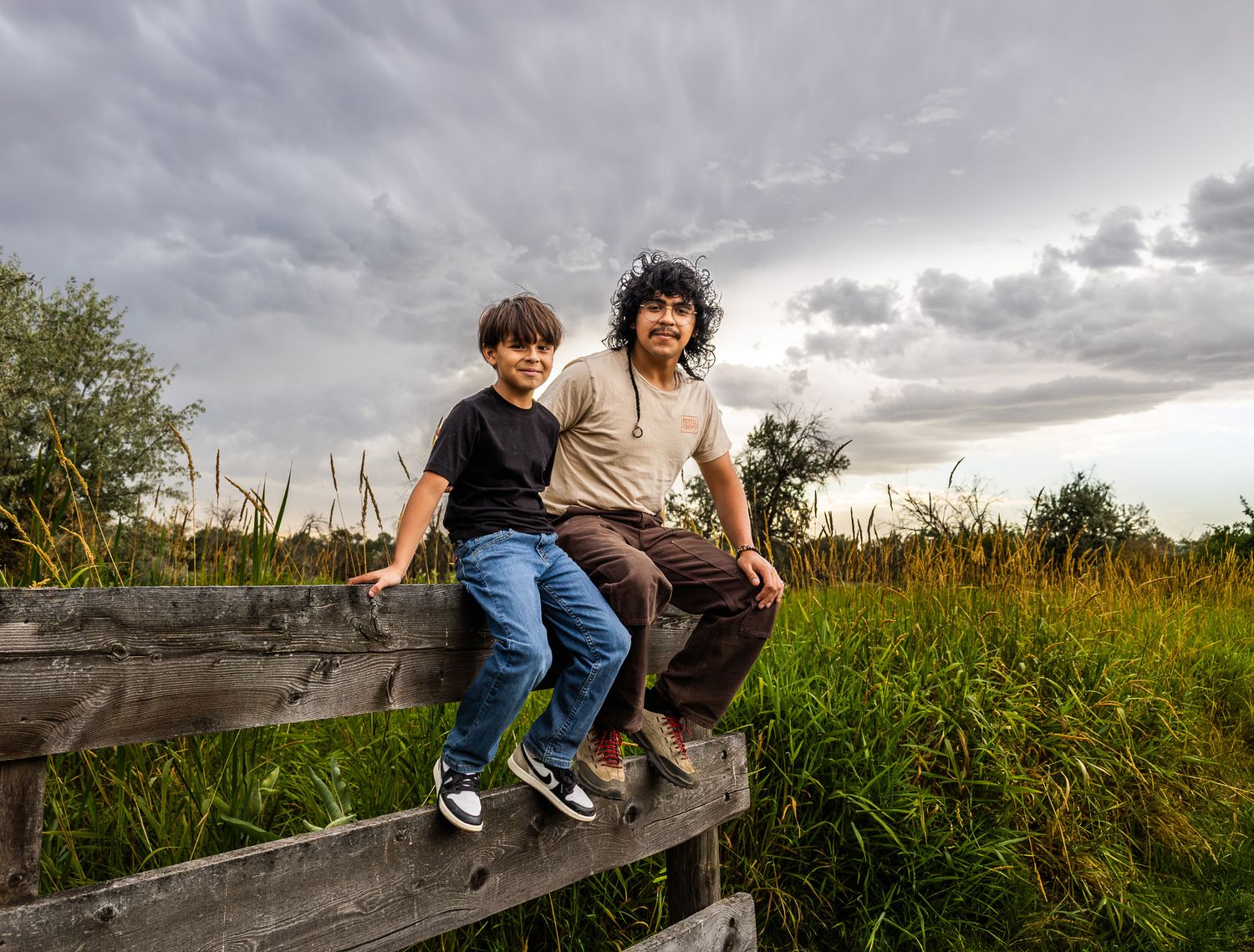 A series of images showing someone climbing over a wooden fence in a grassy field at sunset.