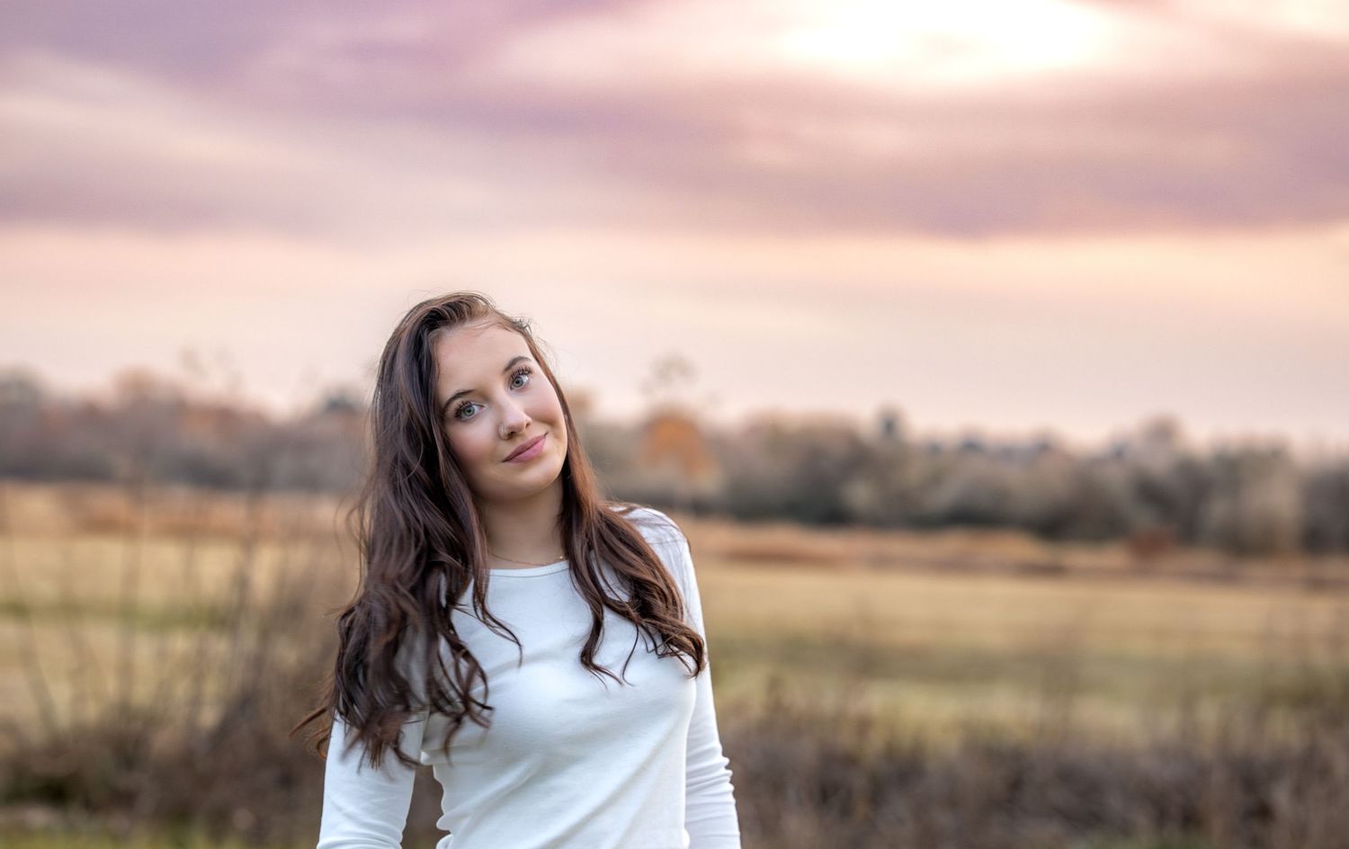 Scenic outdoor portraits at sunset with soft golden lighting and natural landscape backgrounds.
