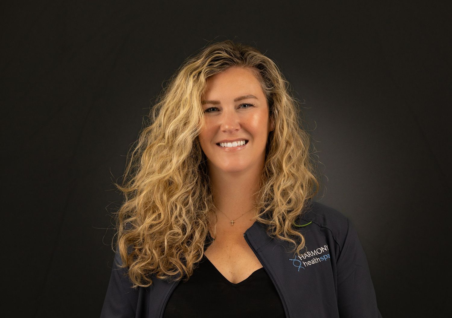 Professional headshot portraits of someone with wavy blonde hair against a dark background.
