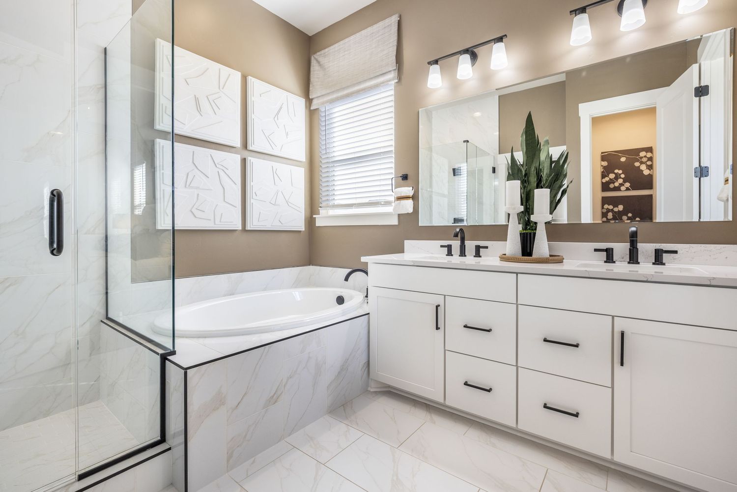 Modern white bathroom features glass shower enclosure, floating vanity, and chrome fixtures with natural light from window.