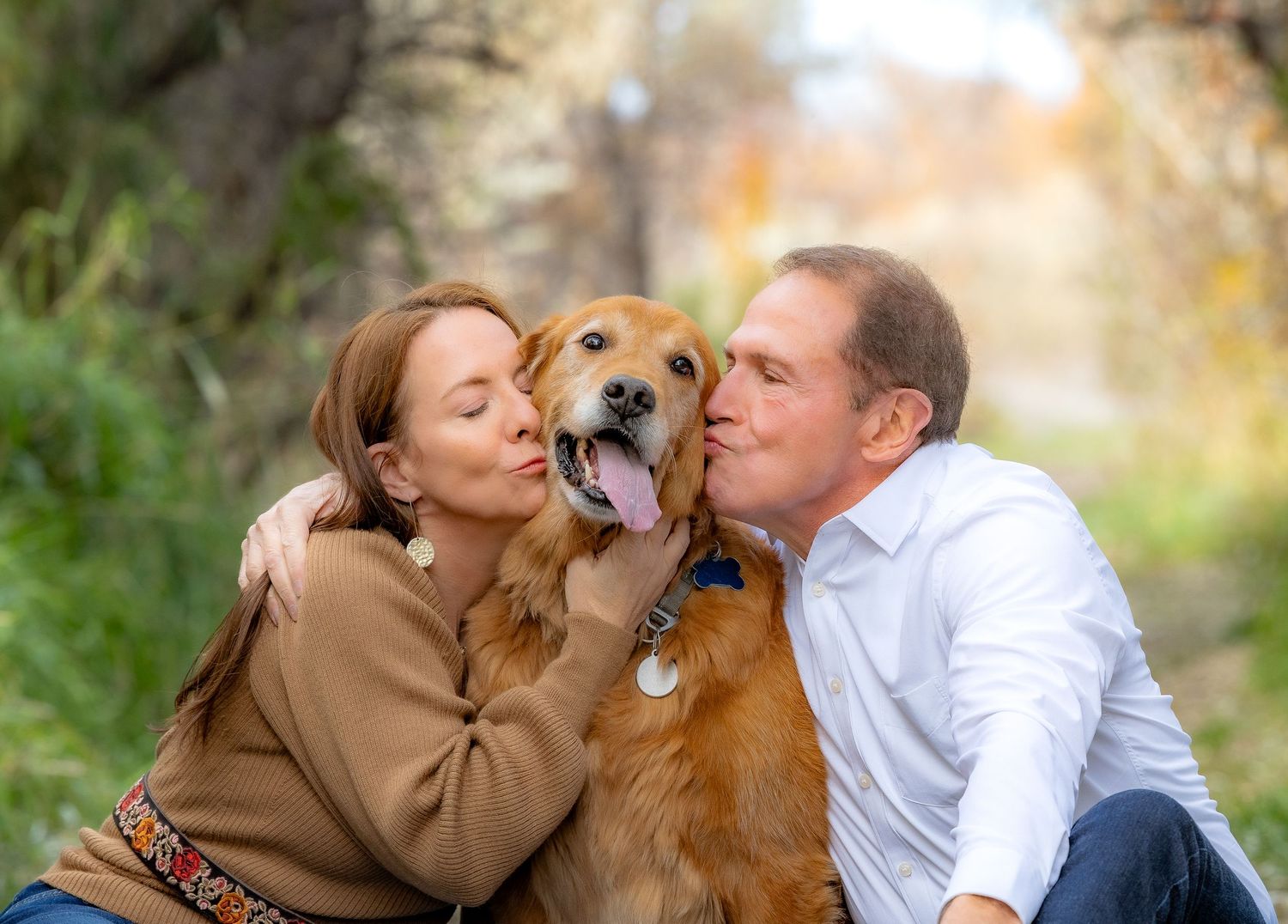 A couple shares affectionate moments with their golden retriever dog in a series of outdoor photos.
