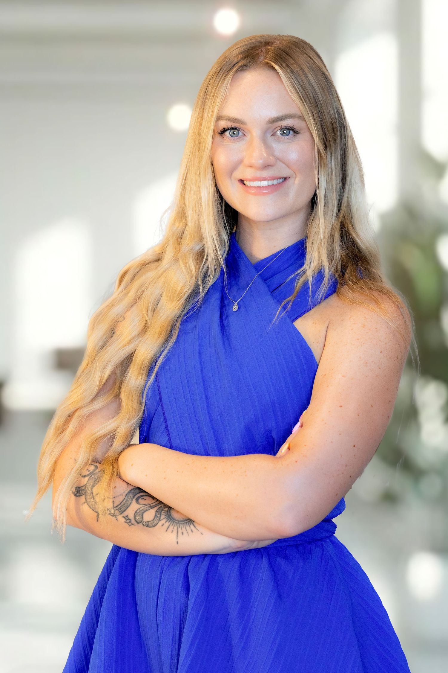 A person wearing a bright royal blue sleeveless dress poses against a light background in a photo series.