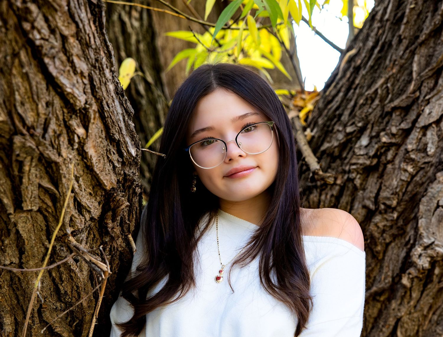A series of outdoor portrait photos taken against a tree trunk backdrop in natural lighting.