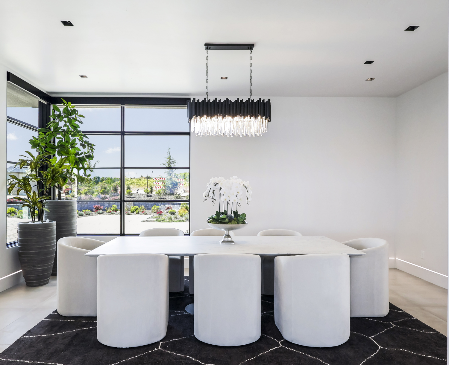 Modern luxury open floor plan interior with white round seating and panoramic windows in minimalist architectural style.