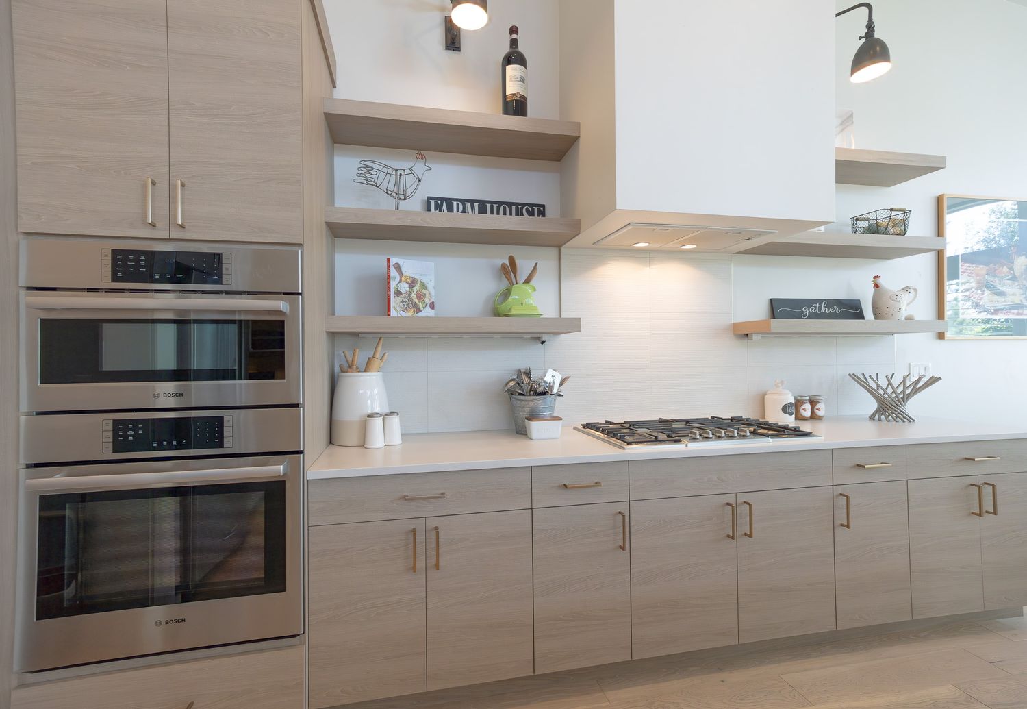 Modern light wood kitchen featuring built-in appliances, floating shelves, and sleek cabinetry with under-cabinet lighting.