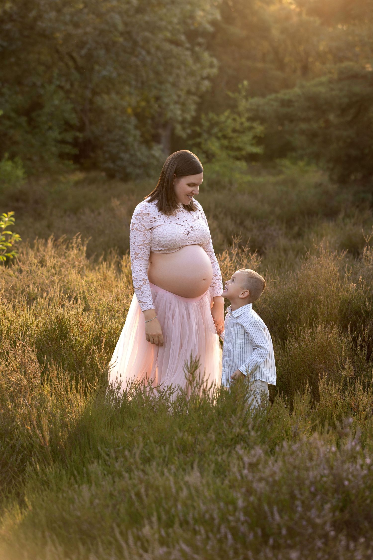 A tender moment captured between parent and child in a sunlit meadow during golden hour.