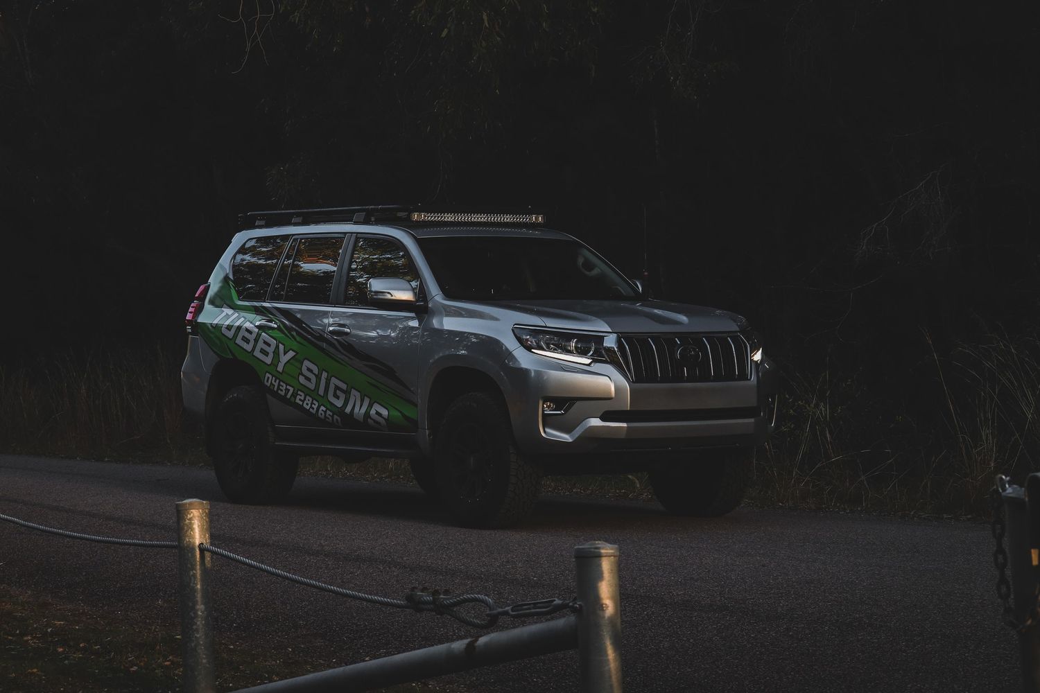SUVs parked in dim lighting conditions in a dark outdoor setting.