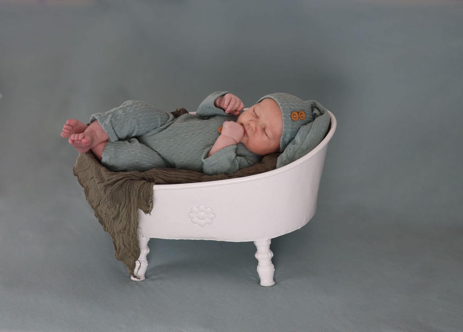 A serene figure relaxes in a vintage white clawfoot bathtub against a moody gray backdrop.