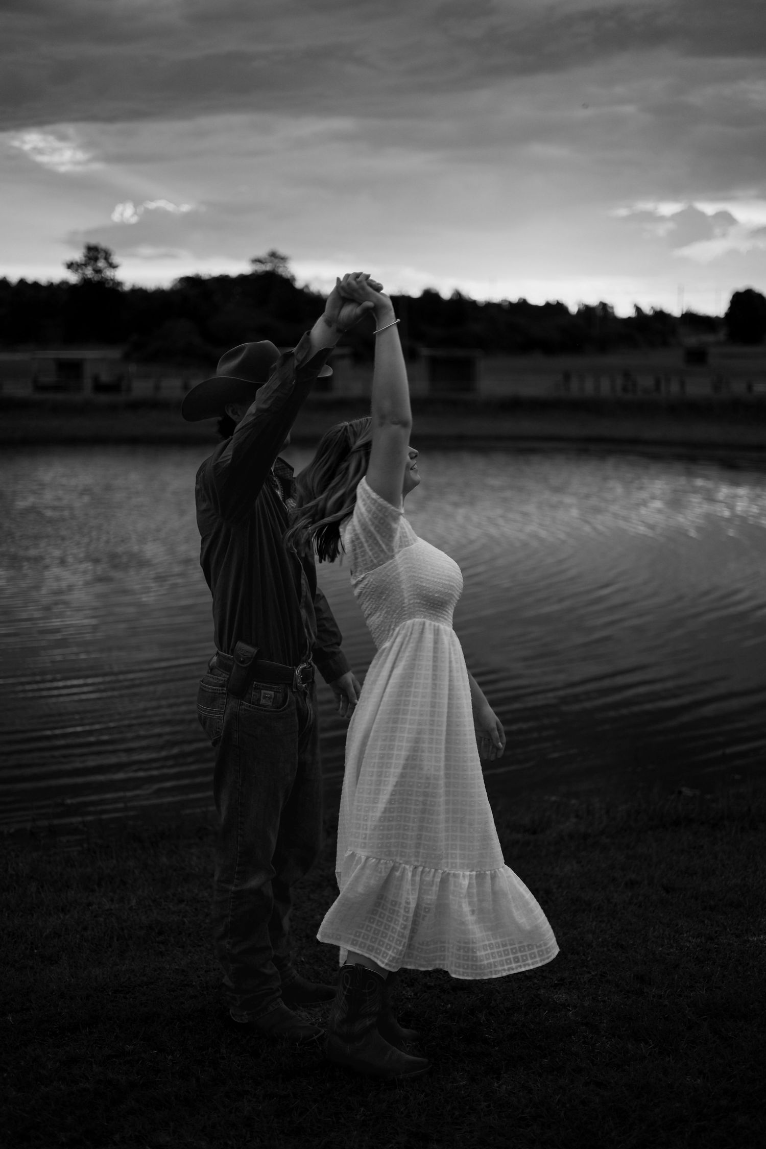 A black and white series of photos showing two figures dancing by a lake at sunset in vintage clothing.