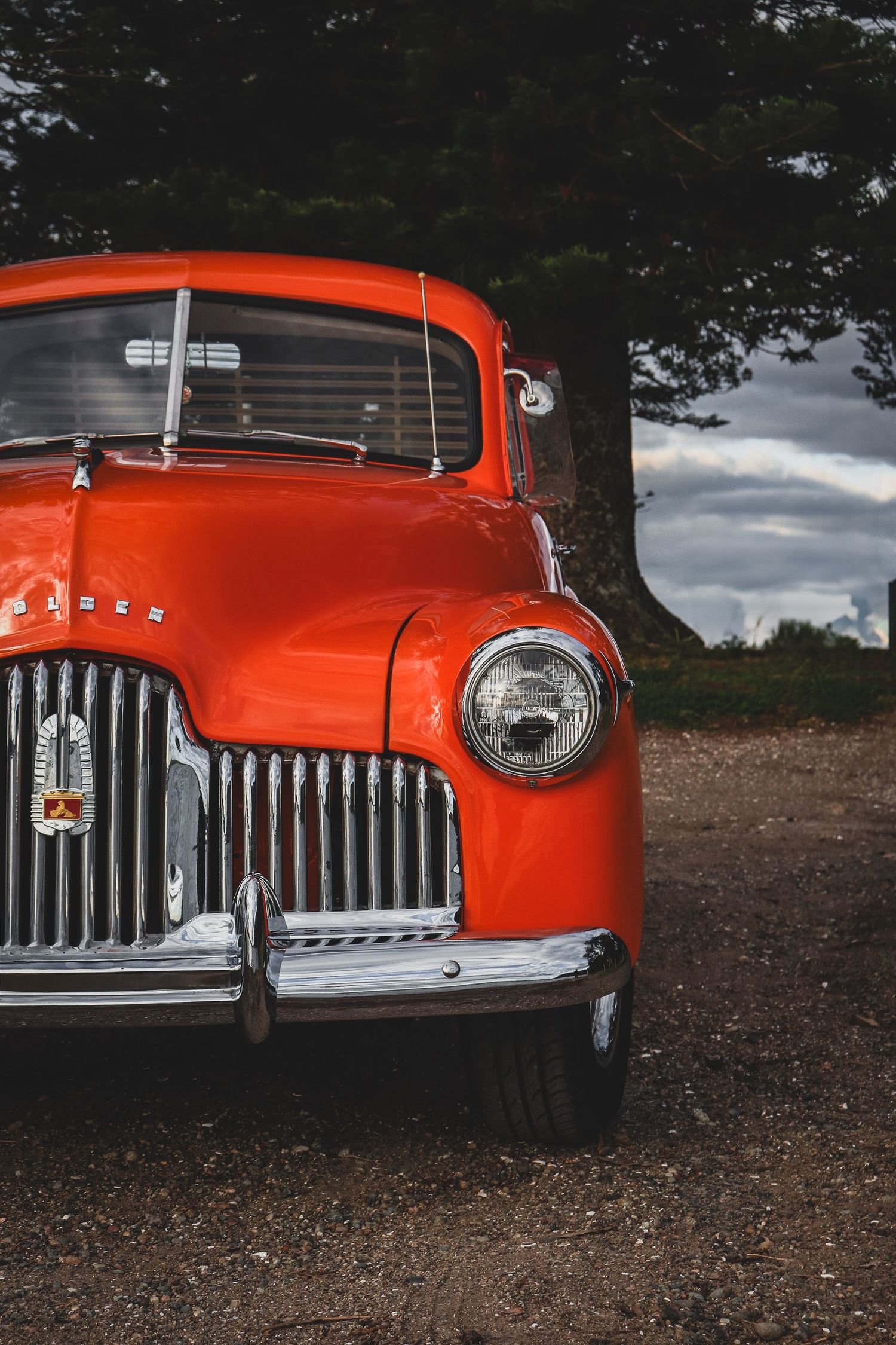 Close-up views of a classic vintage front grille and headlights against an outdoor background.