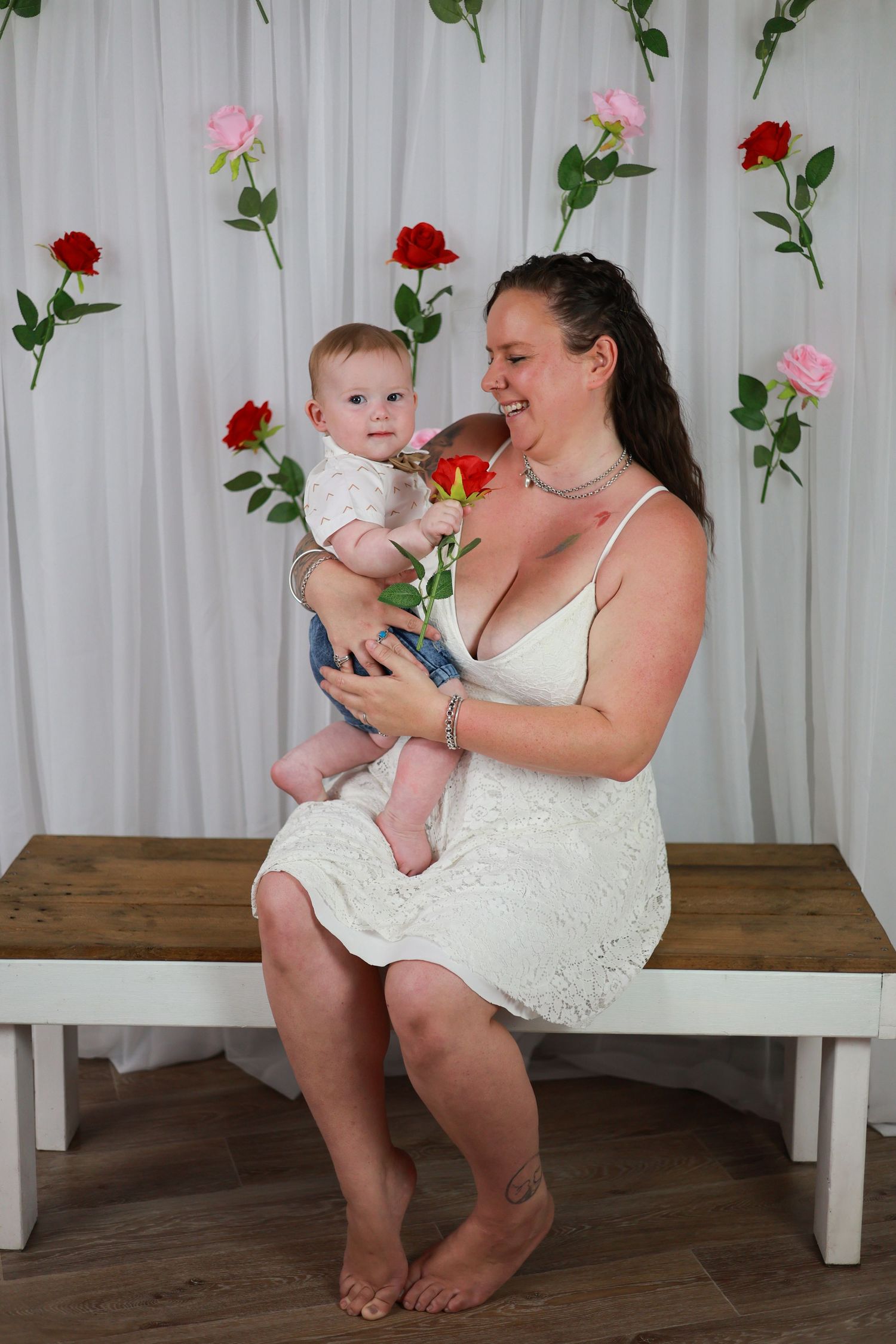 Four connected images show a woman in white dress sitting on bench with baby, displaying joyful interactions on wooden floor.