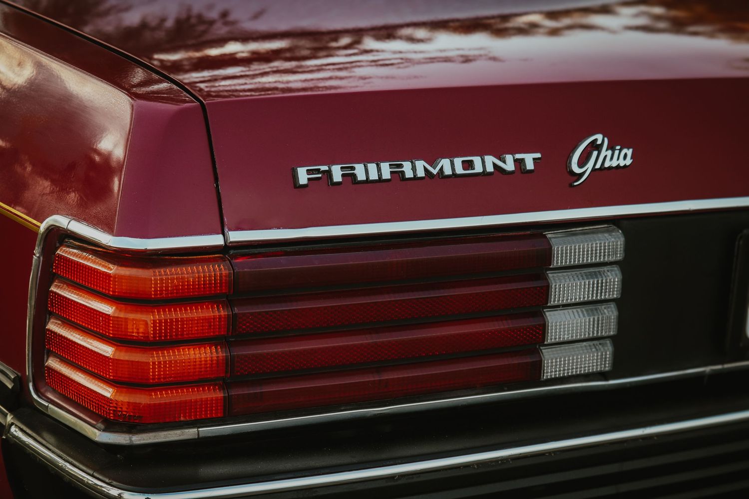 Close-up view of red Ford Fairmont Ghia taillight assembly showing chrome trim and distinctive brake light design.