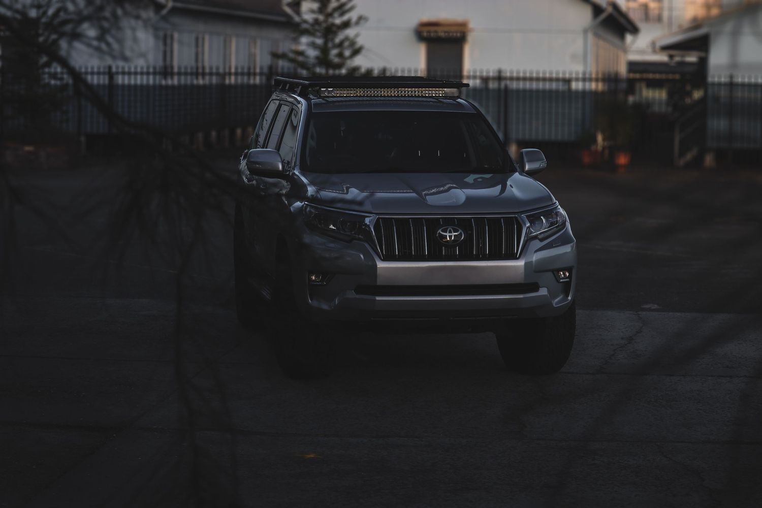 SUV vehicle parked outside during sunset with silver metallic paint reflecting golden evening light.