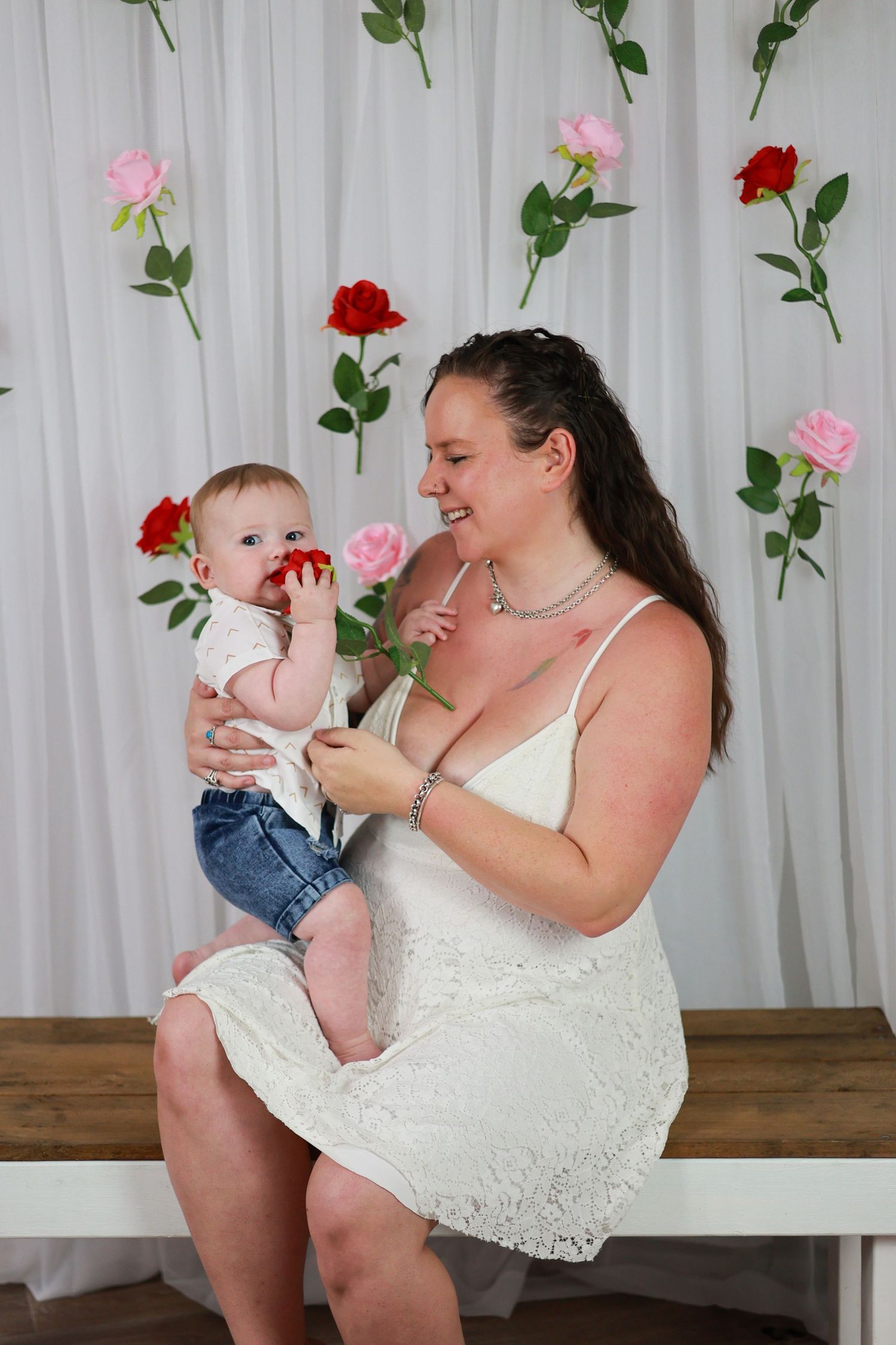 A series of sweet interactive moments between an adult and baby against a floral backdrop with pink and red roses.