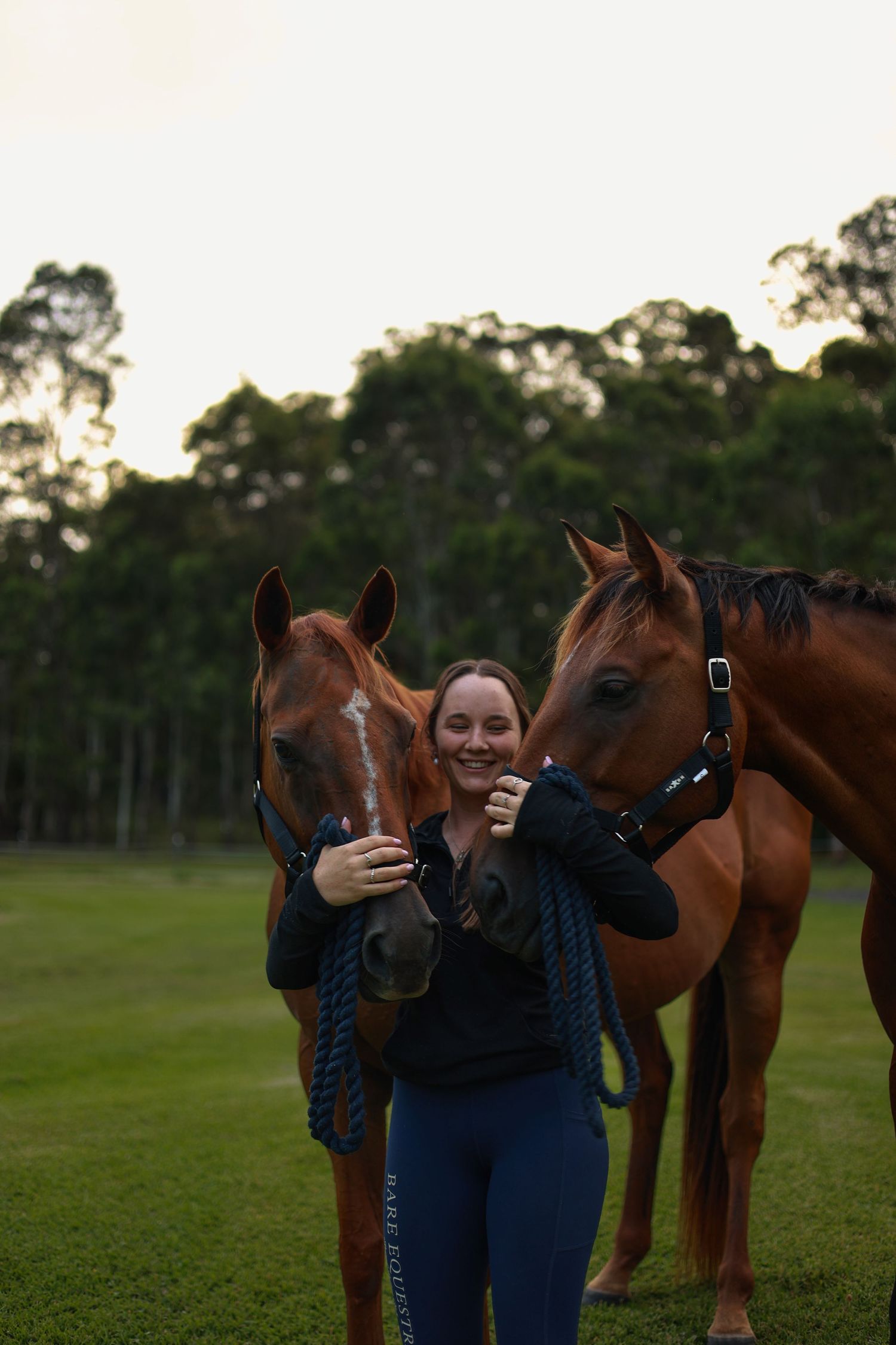 A series of photos showing someone embracing and bonding with horses in a grassy field at sunset.