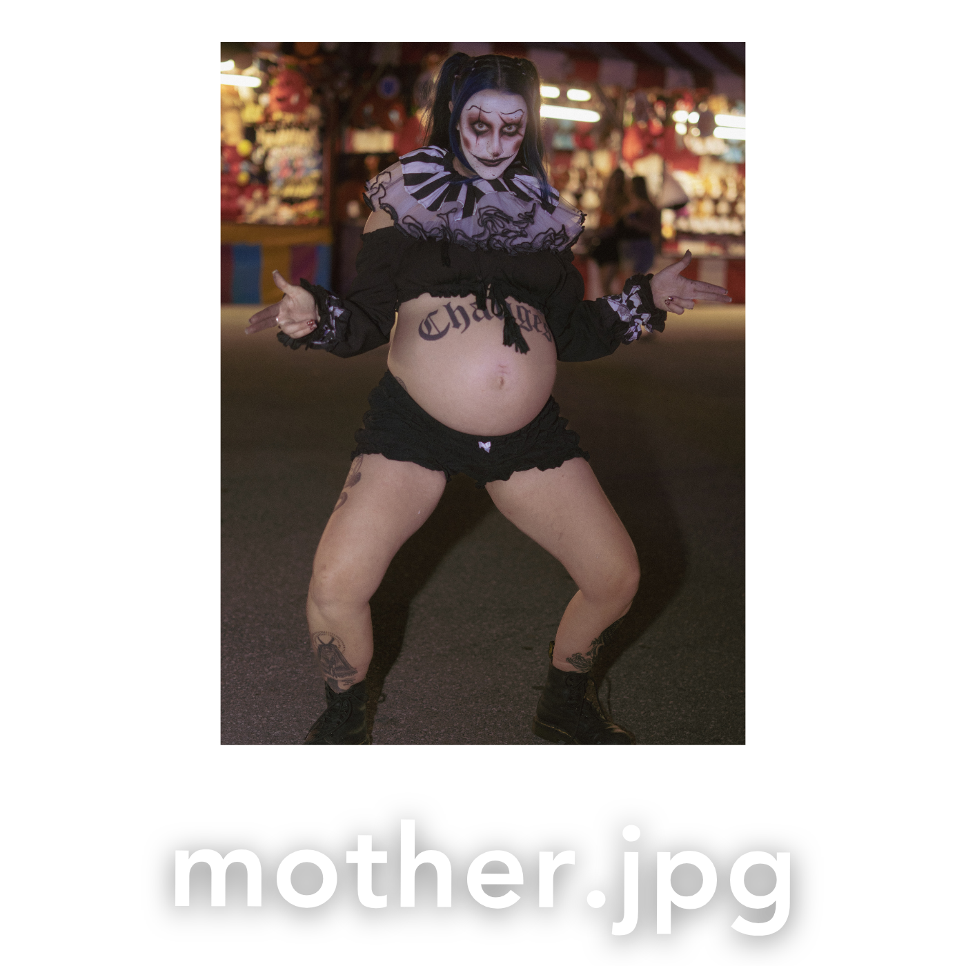 Pregnant woman in Halloween skeleton costume with face paint posing outdoors at night festival.