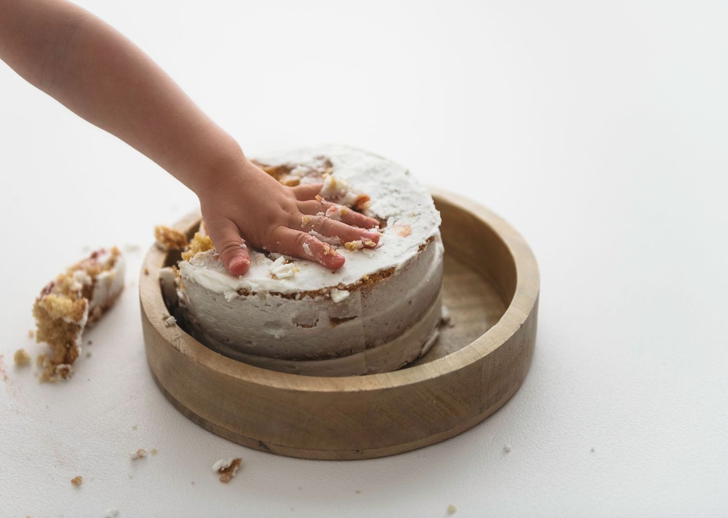 Hands pressing dough onto a flat rustic clay or ceramic plate in sequence from left to right.