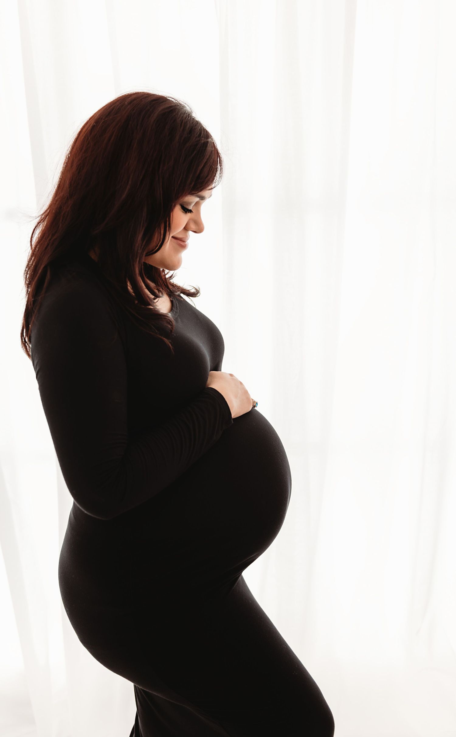 Silhouette profile series of a pregnant woman in black against a white background showing her growing belly.