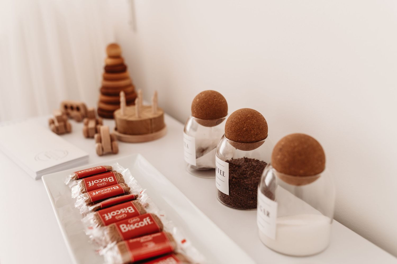 Artisanal chocolate truffles and bonbons displayed on white surfaces with geometric shapes and decorative elements.