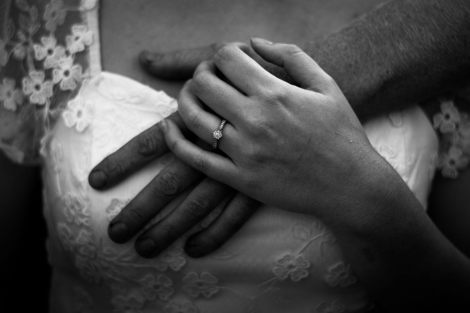 couple holding hands showing off engagement ring